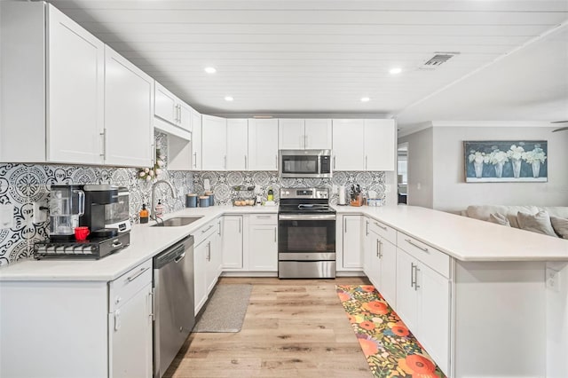 980 8th Ave NE, Largo, FL 33770 - kitchen with stainless steel appliances, a peninsula, light wood finished floors, light countertops, and recessed lighting