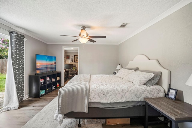 980 8th Ave NE, Largo, FL 33770 - bedroom featuring wood finished floors, a textured ceiling, crown molding, and ceiling fan