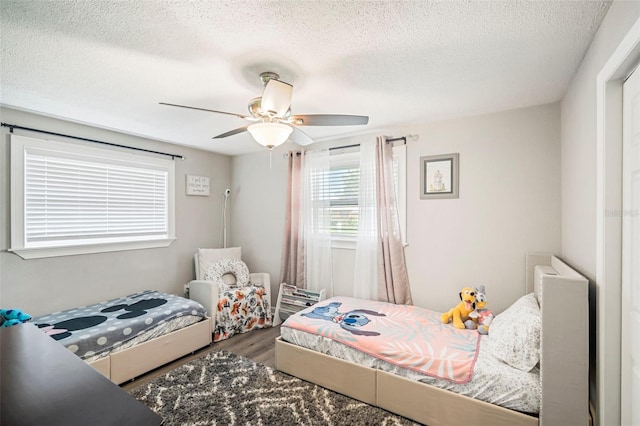 980 8th Ave NE, Largo, FL 33770 - bedroom featuring wood finished floors, a textured ceiling, and ceiling fan
