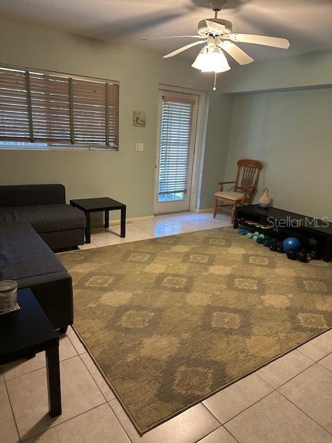 9810 Indian Key Trl Unit 85, Seminole, FL 33776 - living area featuring light tile patterned floors, ceiling fan, and light carpet