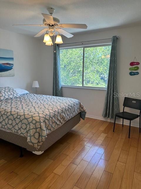 9810 Indian Key Trl Unit 85, Seminole, FL 33776 - bedroom with light wood-type flooring and a ceiling fan
