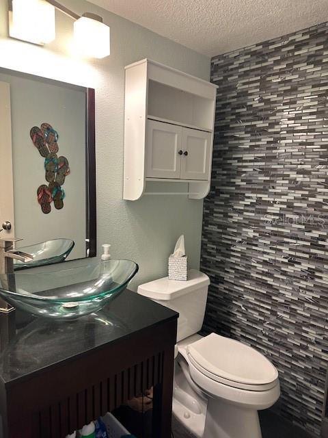 9810 Indian Key Trl Unit 85, Seminole, FL 33776 - bathroom featuring a textured ceiling and vanity