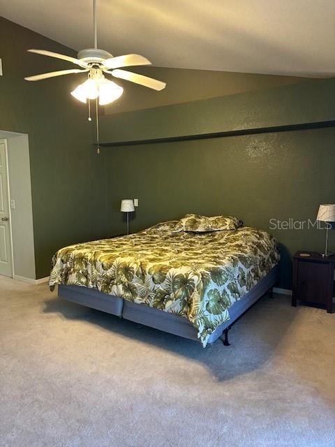 9810 Indian Key Trl Unit 85, Seminole, FL 33776 - carpeted bedroom featuring lofted ceiling and a ceiling fan