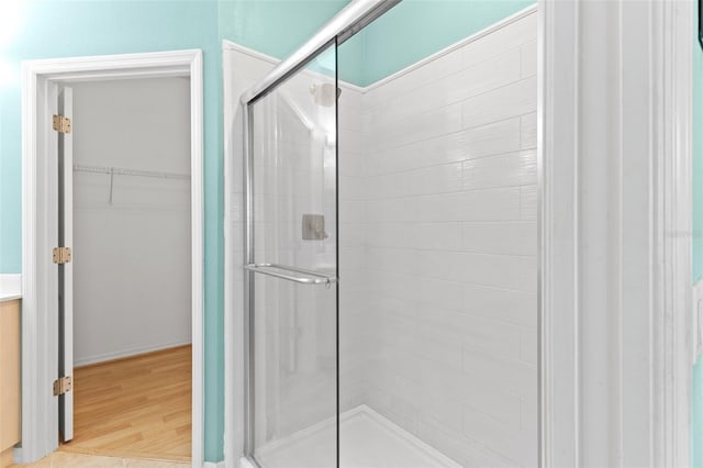 2468 Magnolia Cir, North Port, FL 34289 - bathroom with a shower stall, a spacious closet, and wood finished floors