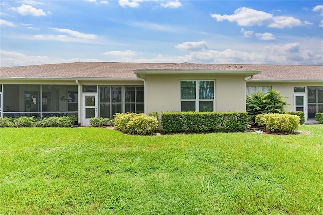 2468 Magnolia Cir, North Port, FL 34289 - rear view of house with stucco siding, a sunroom, and a lawn