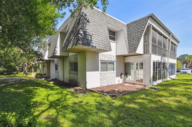 3415 Tricon Ln Unit 13, Holiday, FL 34691 - rear view of property with stucco siding, mansard roof, a lawn, roof with shingles, and french doors