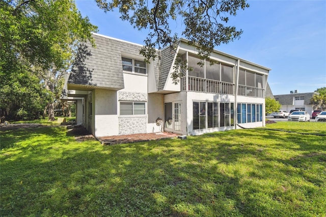 3415 Tricon Ln Unit 13, Holiday, FL 34691 - back of property featuring mansard roof, a shingled roof, a sunroom, and a lawn