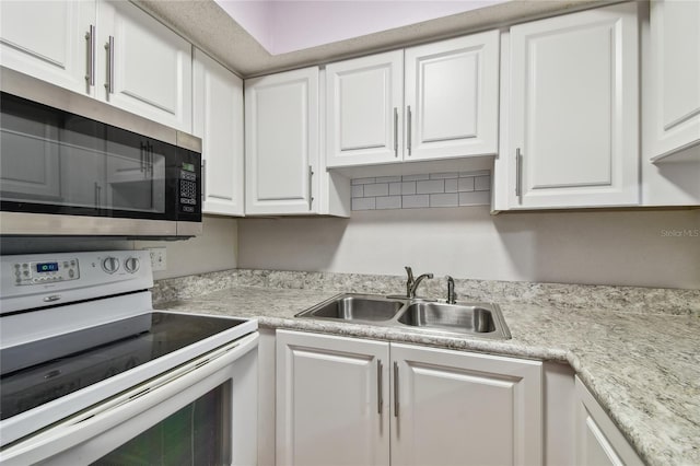 3415 Tricon Ln Unit 13, Holiday, FL 34691 - kitchen with white range with electric cooktop, stainless steel microwave, white cabinetry, and light countertops