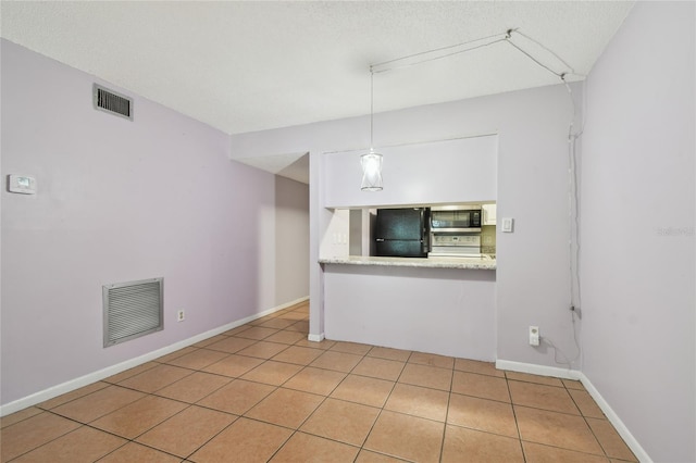 3415 Tricon Ln Unit 13, Holiday, FL 34691 - unfurnished room featuring light tile patterned floors and a textured ceiling