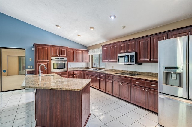 3685 N Palomino Ter, Beverly Hills, FL 34465 - kitchen featuring appliances with stainless steel finishes, lofted ceiling, an island with sink, light tile patterned flooring, and light stone countertops