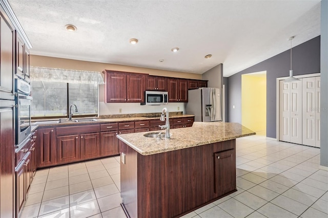 3685 N Palomino Ter, Beverly Hills, FL 34465 - kitchen featuring stainless steel appliances, vaulted ceiling, light tile patterned floors, a center island with sink, and light stone counters