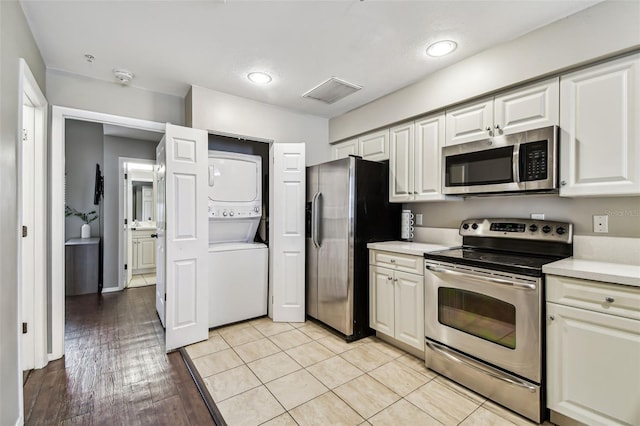 1914 E 4th Ave Unit 2, Tampa, FL 33605 - kitchen featuring appliances with stainless steel finishes, stacked washer and clothes dryer, light countertops, white cabinetry, and recessed lighting