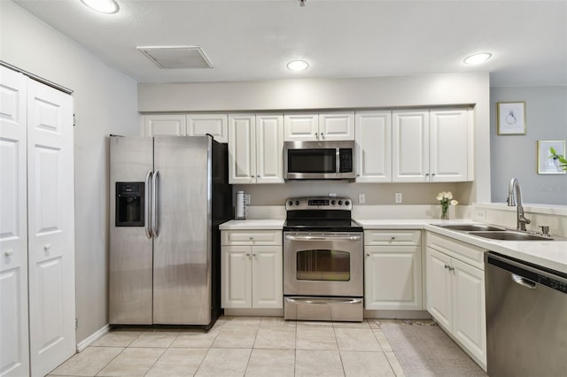 1914 E 4th Ave Unit 2, Tampa, FL 33605 - kitchen featuring appliances with stainless steel finishes, light countertops, light tile patterned floors, white cabinets, and recessed lighting