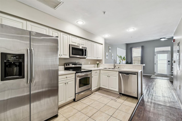 1914 E 4th Ave Unit 2, Tampa, FL 33605 - kitchen featuring appliances with stainless steel finishes, a peninsula, light countertops, white cabinetry, and recessed lighting