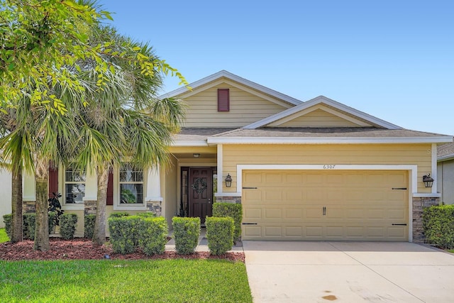 6307 Shadowlake Dr, Apollo Beach, FL 33572 - view of front of house with stone siding, concrete driveway, and a garage