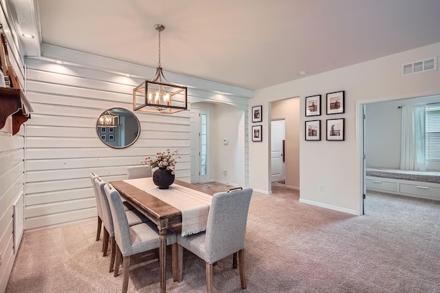 6307 Shadowlake Dr, Apollo Beach, FL 33572 - dining space featuring arched walkways, light colored carpet, a chandelier, and wooden walls