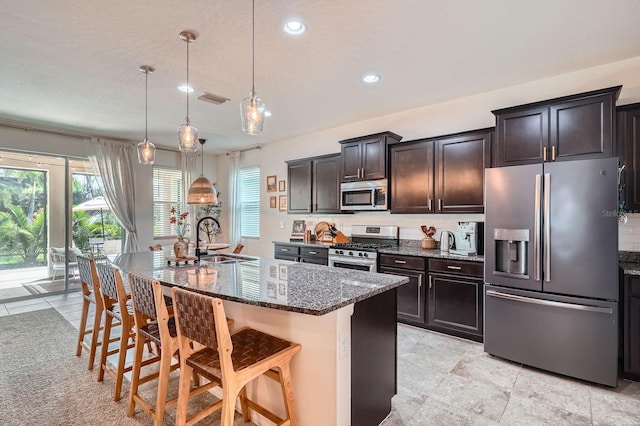 6307 Shadowlake Dr, Apollo Beach, FL 33572 - kitchen featuring stainless steel appliances, dark stone countertops, recessed lighting, a breakfast bar area, and tasteful backsplash