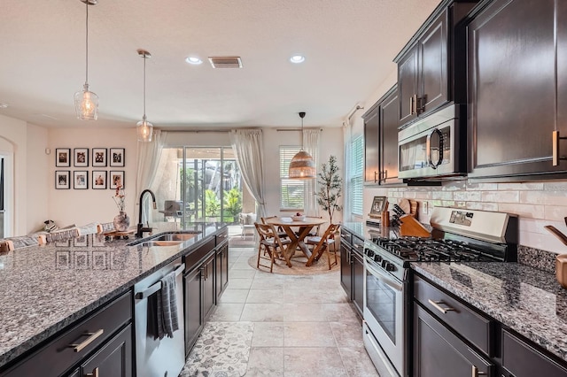 6307 Shadowlake Dr, Apollo Beach, FL 33572 - kitchen with appliances with stainless steel finishes, dark stone countertops, decorative backsplash, recessed lighting, and pendant lighting