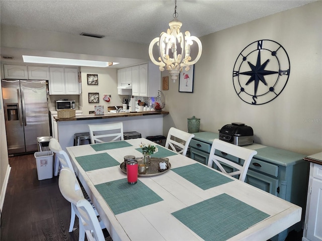 6356 7th Ave W Unit 6356, Bradenton, FL 34209 - dining area featuring a chandelier, a textured ceiling, and dark wood-style flooring