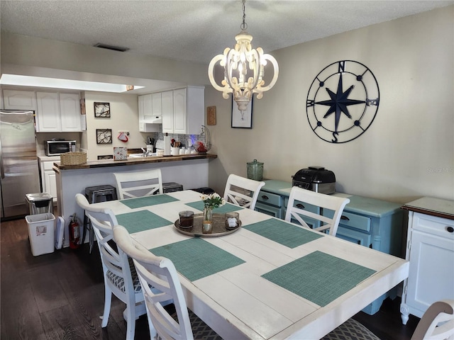 6356 7th Ave W Unit 6356, Bradenton, FL 34209 - dining area with dark wood-type flooring, a chandelier, and a textured ceiling