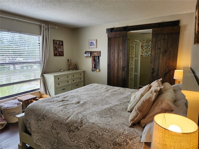 6356 7th Ave W Unit 6356, Bradenton, FL 34209 - bedroom with a textured ceiling, a barn door, and wood finished floors