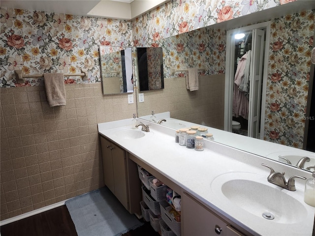 6356 7th Ave W Unit 6356, Bradenton, FL 34209 - full bathroom featuring wallpapered walls, tile walls, double vanity, and wainscoting