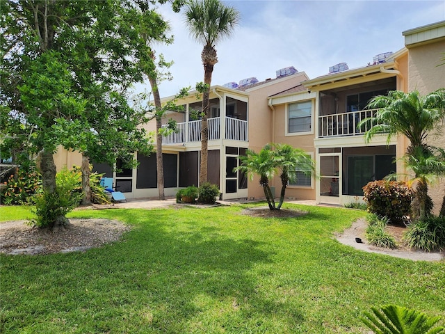 6356 7th Ave W Unit 6356, Bradenton, FL 34209 - back of house with stucco siding, a yard, and a sunroom