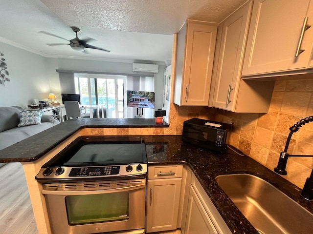 880 Mandalay Ave Unit C206, Clearwater, FL 33767 - kitchen featuring stainless steel electric range, black microwave, a textured ceiling, a ceiling fan, and open floor plan