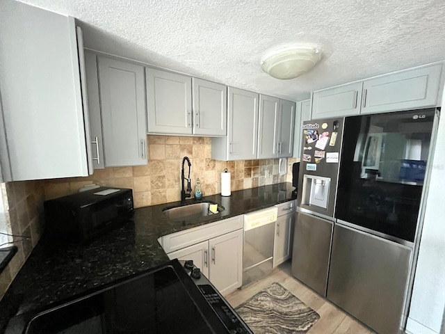 880 Mandalay Ave Unit C206, Clearwater, FL 33767 - kitchen with black appliances, backsplash, a textured ceiling, and dark stone counters