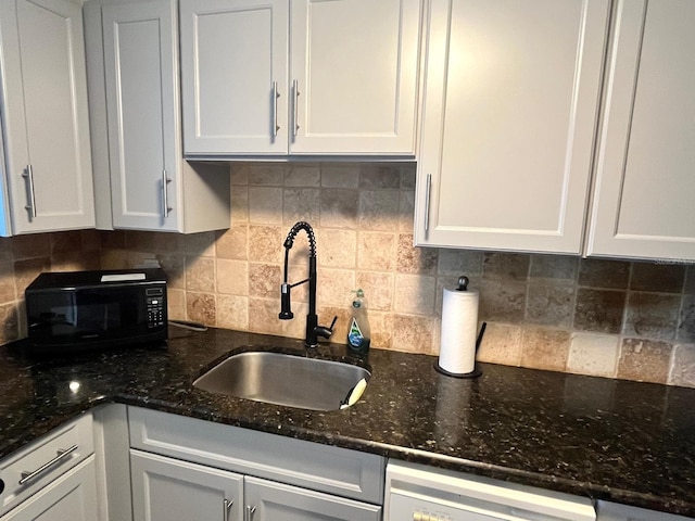 880 Mandalay Ave Unit C206, Clearwater, FL 33767 - kitchen featuring white cabinetry, backsplash, black microwave, dishwasher, and dark stone counters