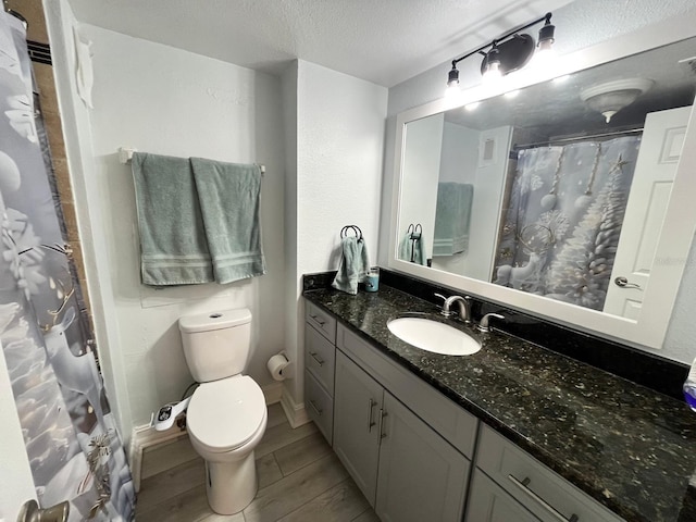 880 Mandalay Ave Unit C206, Clearwater, FL 33767 - bathroom with vanity, a textured ceiling, wood finish floors, and curtained shower