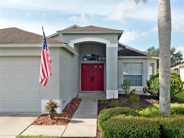 11802 Aintree Ct, Trinity, FL 34655 - view of front of home with an attached garage, stucco siding, and a shingled roof