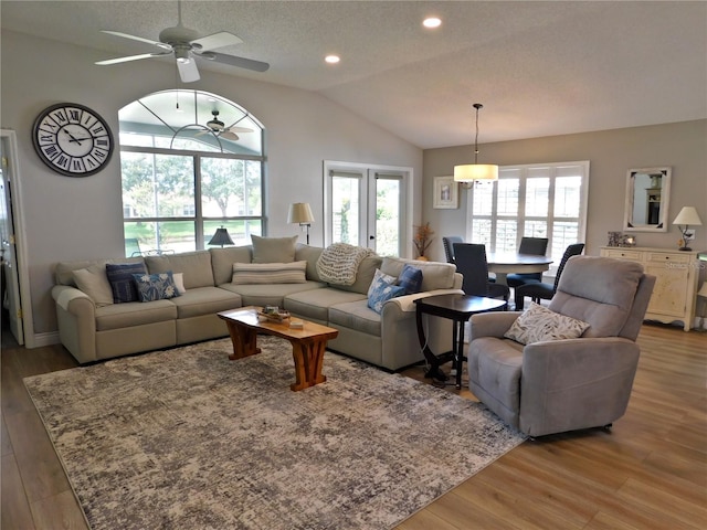 11802 Aintree Ct, Trinity, FL 34655 - living room with light wood finished floors, vaulted ceiling, a ceiling fan, recessed lighting, and a textured ceiling