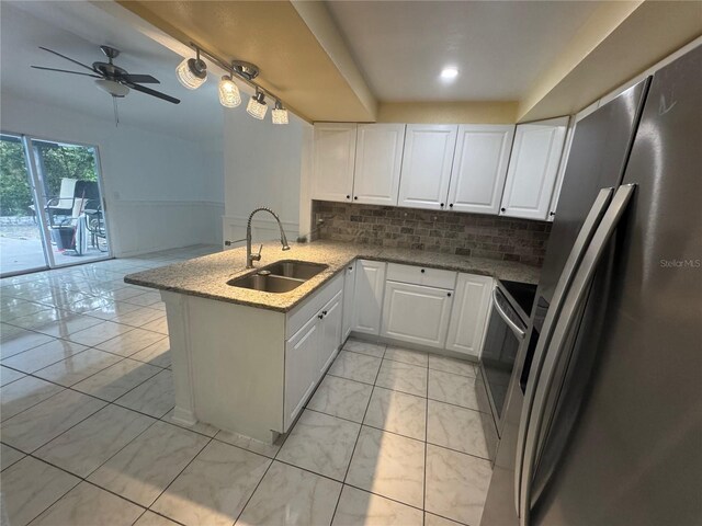 6133 Arthur Ave, New Port Richey, FL 34653 - kitchen featuring freestanding refrigerator, a peninsula, white cabinets, backsplash, and ceiling fan