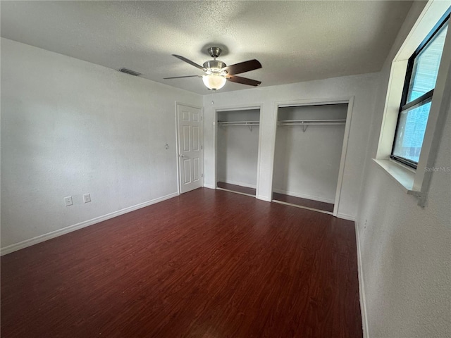 6133 Arthur Ave, New Port Richey, FL 34653 - unfurnished bedroom with multiple closets, wood finished floors, a textured ceiling, and ceiling fan