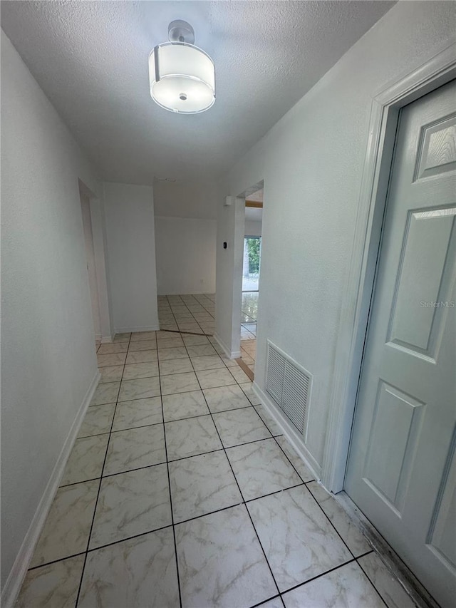 6133 Arthur Ave, New Port Richey, FL 34653 - corridor with light marble finish floors and a textured ceiling