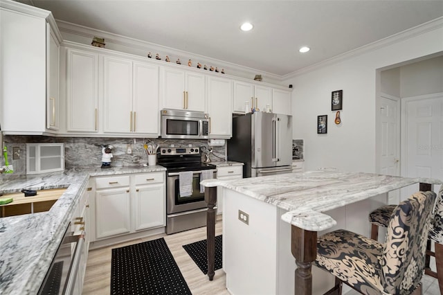 11132 Running Pine Dr, Riverview, FL 33569 - kitchen featuring appliances with stainless steel finishes, a breakfast bar, a kitchen island, white cabinetry, and recessed lighting