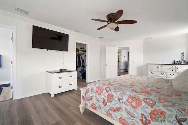 11132 Running Pine Dr, Riverview, FL 33569 - bedroom featuring ornamental molding, dark wood-style floors, a walk in closet, and a ceiling fan