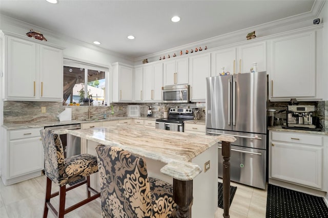 11132 Running Pine Dr, Riverview, FL 33569 - kitchen with stainless steel appliances, a breakfast bar area, a kitchen island, decorative backsplash, and crown molding