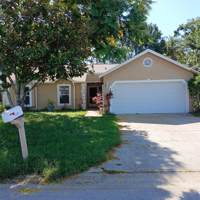 7674 37th Street Cir E, Sarasota, FL 34243 - view of front of property with stucco siding, an attached garage, driveway, and a front yard