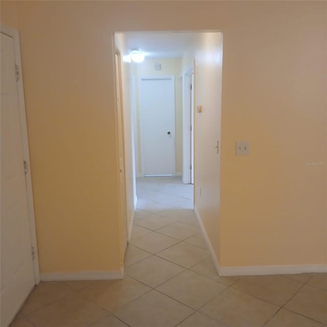 7674 37th Street Cir E, Sarasota, FL 34243 - hallway featuring light tile patterned flooring and baseboards