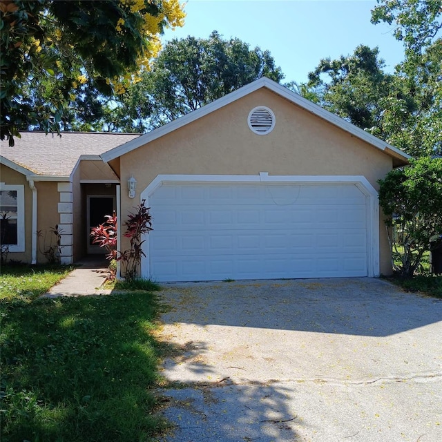 7674 37th Street Cir E, Sarasota, FL 34243 - ranch-style home featuring stucco siding, an attached garage, driveway, and a shingled roof