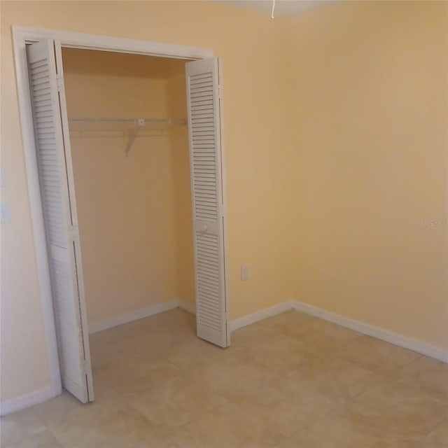 7674 37th Street Cir E, Sarasota, FL 34243 - unfurnished bedroom with a closet and baseboards