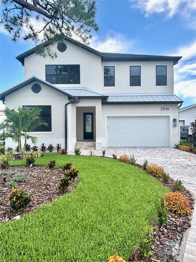 2516 W Abdella St, Tampa, FL 33607 - view of front of home with stucco siding, a standing seam roof, an attached garage, decorative driveway, and a front lawn