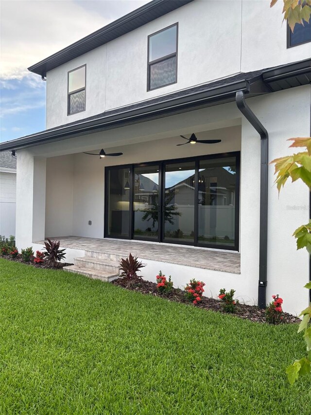 2516 W Abdella St, Tampa, FL 33607 - back of property featuring stucco siding, a yard, and a ceiling fan