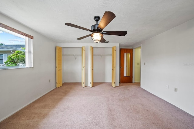 4371 Otter Way, New Port Richey, FL 34653 - unfurnished bedroom featuring multiple closets, light colored carpet, and ceiling fan
