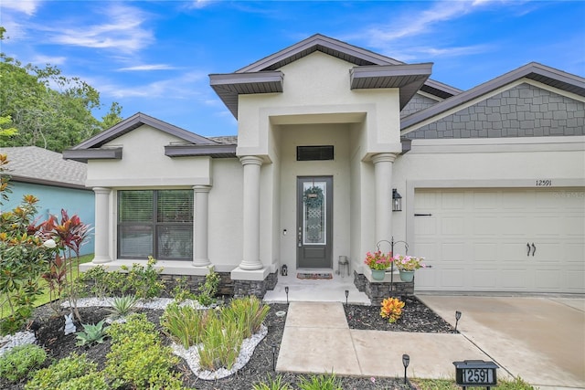12591 Vander Way, New Port Richey, FL 34654 - entrance to property featuring stucco siding, an attached garage, driveway, and stone siding