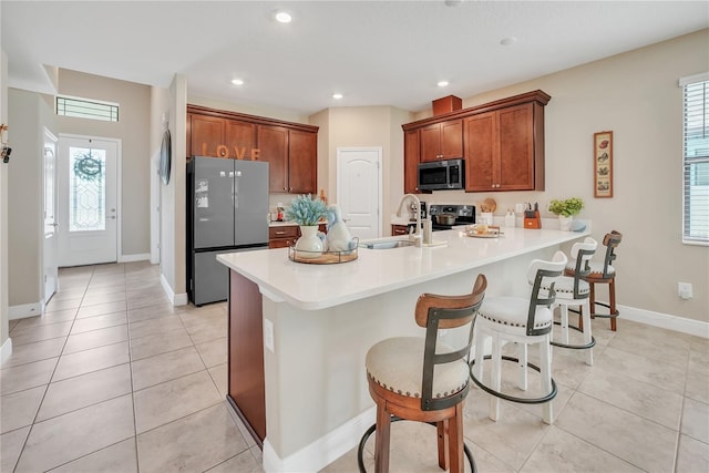 12591 Vander Way, New Port Richey, FL 34654 - kitchen featuring stainless steel appliances, a peninsula, light tile patterned floors, a breakfast bar area, and light countertops