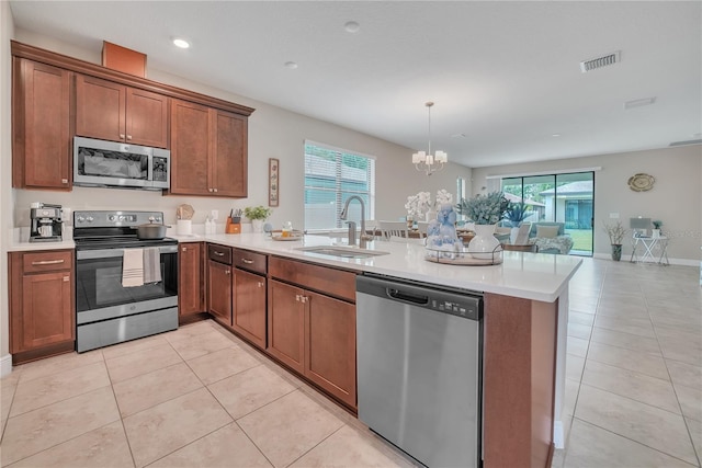 12591 Vander Way, New Port Richey, FL 34654 - kitchen featuring stainless steel appliances, a peninsula, a chandelier, open floor plan, and light countertops