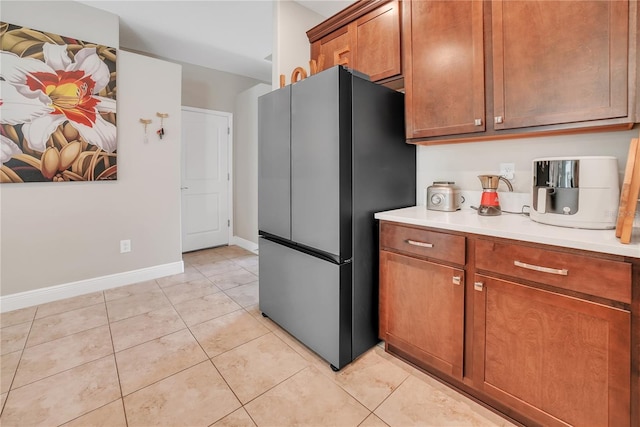 12591 Vander Way, New Port Richey, FL 34654 - kitchen with freestanding refrigerator, light countertops, light tile patterned floors, and brown cabinets